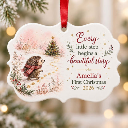 Scalloped ceramic ornament with hedgehog in red plaid scarf walking toward a decorated Christmas tree in the snow.
