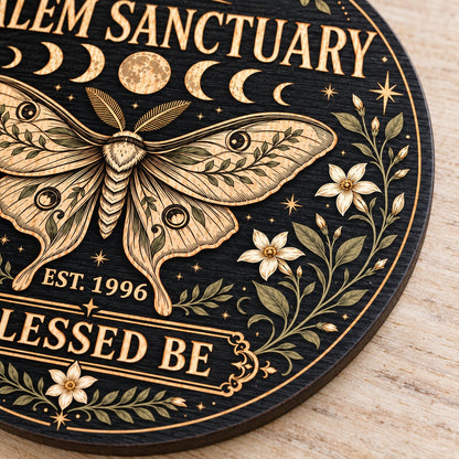 Round wooden sign with a central moth, moon phases, floral vines, stars, and 'Salem Sanctuary' 'Blessed Be' text.