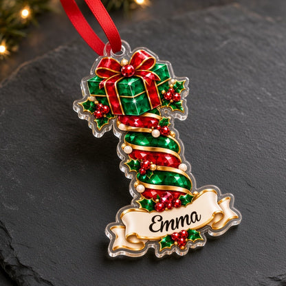 Acrylic ornament with green gift box and smiling elf, jeweled spiral columns, holly, and a name banner.