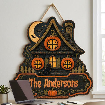 Custom-cut haunted house wooden sign with moon, bats, pumpkin windows, black cat, picket fences, and a family name banne
