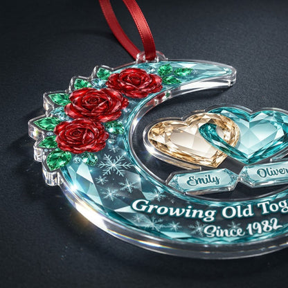 Custom-cut acrylic ornament of a faceted crescent moon with red roses, snowflakes, and two intertwined crystal hearts.
