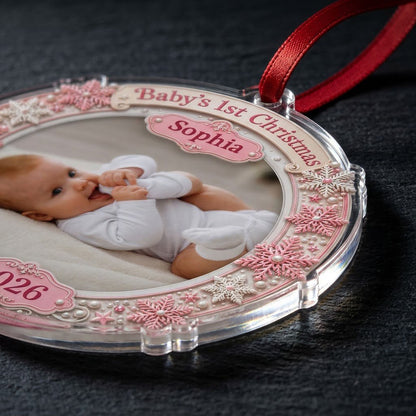 Round acrylic ornament with pink and white snowflakes framing a baby photo and the words Baby's 1st Christmas.