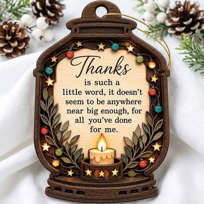 Lantern-shaped wood ornament with candle, colorful fairy lights, leafy branches, and a thank-you quote.