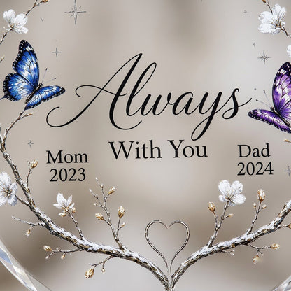 Round glass ornament with branch wreath, white blossoms, blue and purple butterflies, and Always With You text.
