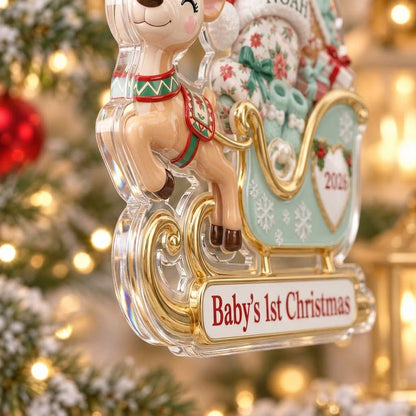 Acrylic ornament of a reindeer pulling a mint-green sleigh with a baby, gifts, and 'Baby's 1st Christmas' text.