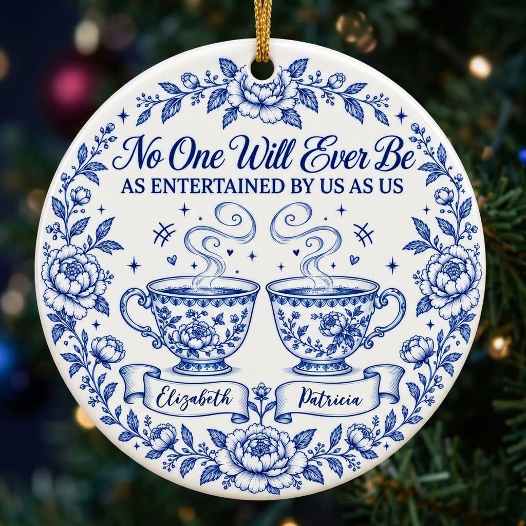 Round white ceramic ornament with blue floral border and two teacups, personalized with two names
