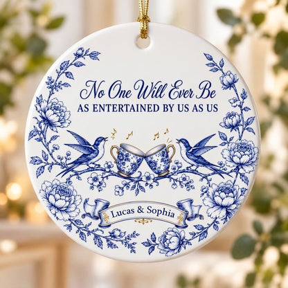 Round ceramic ornament with blue toile border, two birds, clinking floral teacups and gold music notes with two names.