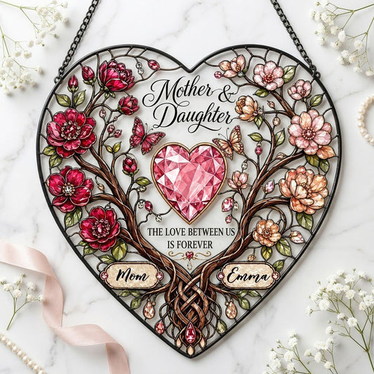 Heart-shaped stained-glass style suncatcher with intertwined trees, red and pink flowers, butterflies, and a pink gem he