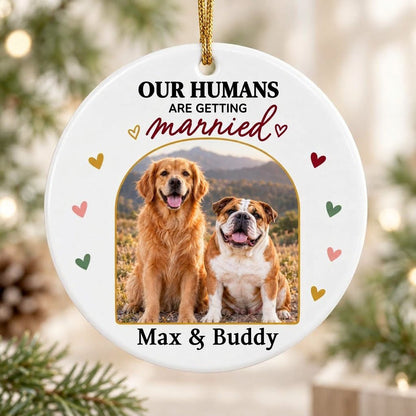 Round ceramic ornament with arch dog photo, “OUR HUMANS ARE GETTING married” text, and colorful heart accents.