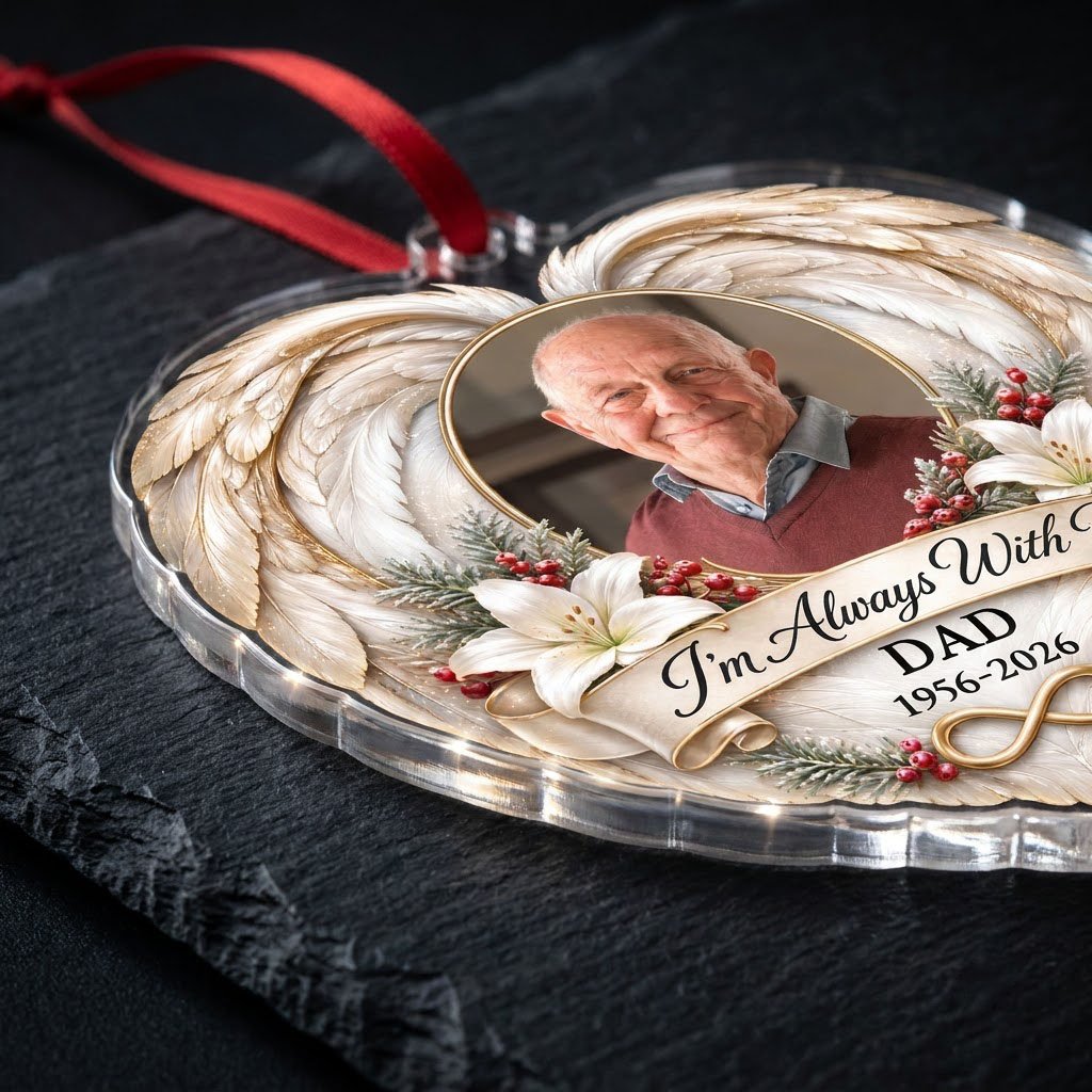 Heart-shaped acrylic ornament with angel wings, oval photo frame, white lilies, pine sprigs, red berries, and 'I'm Alway