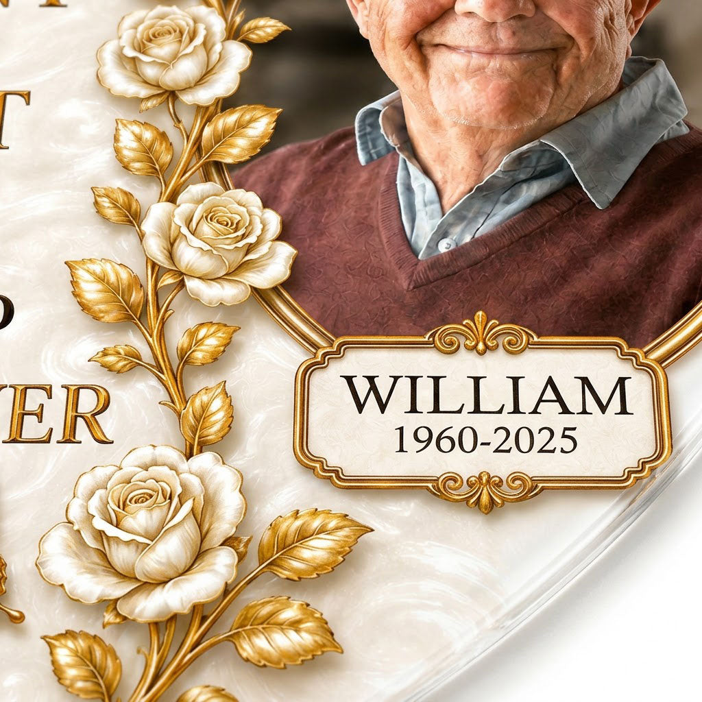Heart-shaped acrylic ornament with a photo in a gold oval frame, white roses, gold butterflies, and a name plaque.