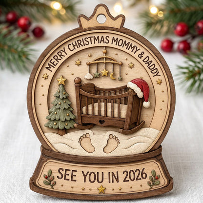 Snow globe wood ornament with crib, Santa hat, mobile, tree, footprints, and Merry Christmas Mommy & Daddy text.
