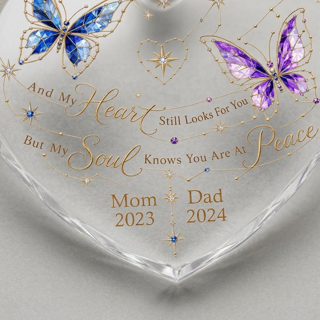 Heart-shaped glass ornament with blue and purple stained-glass butterflies, gold swirls, and memorial text.