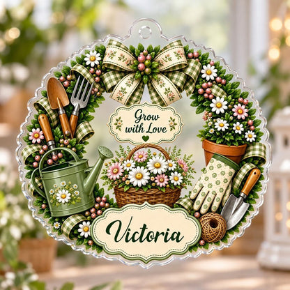 Scalloped acrylic ornament with a floral gardening wreath, tools, and "Grow with Love" plus a personalized name.