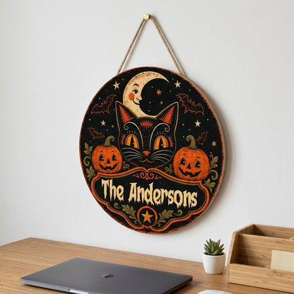 Round wooden sign with vintage black cat face, crescent moon, pumpkins, bats, stars and custom family name.
