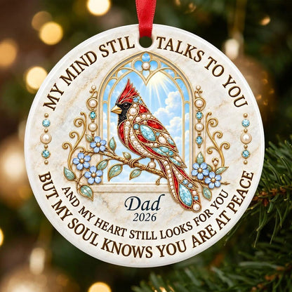 Round ceramic ornament with a red cardinal by a gold arched window, blue flowers, pearls, and a faux marble border.