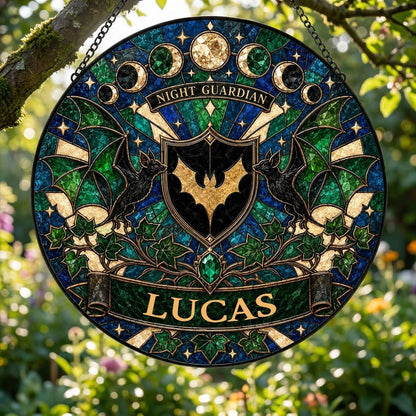 Round stained-glass suncatcher with gold bat shield, two black bats, moon phases, emerald gem, ivy and starbursts.