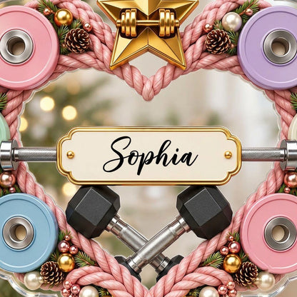 Clear acrylic heart ornament with pink rope wreath, pastel plates, barbell, crossed dumbbells, and a name plaque.