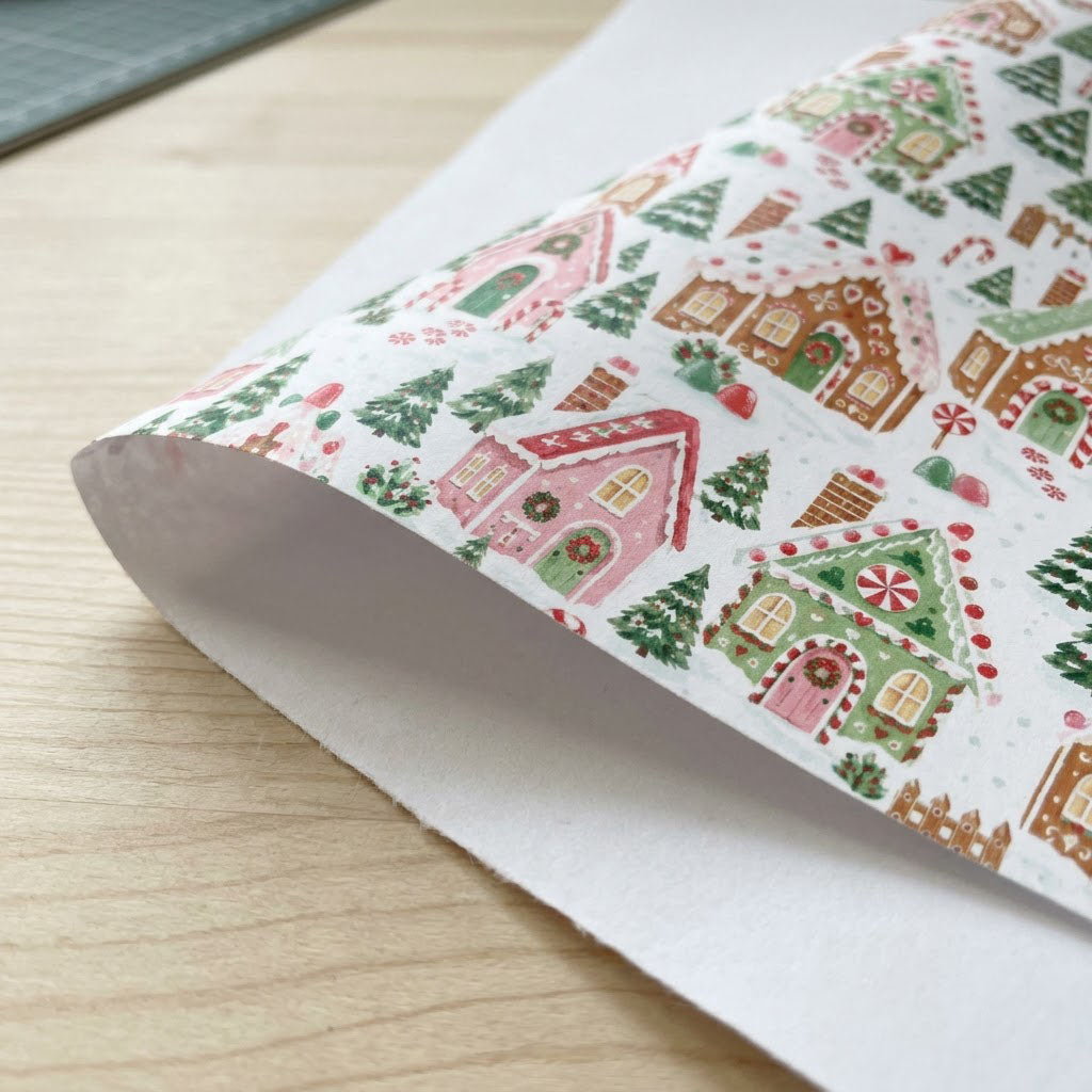 Watercolor gingerbread houses, candy canes, lollipops, pine trees and hearts on snowy white wrapping paper.