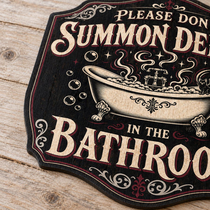 Ornate plaque with tub, bat-winged black cat, bubbles, stars, and 'Please Don't Summon Demons in the Bathroom'.