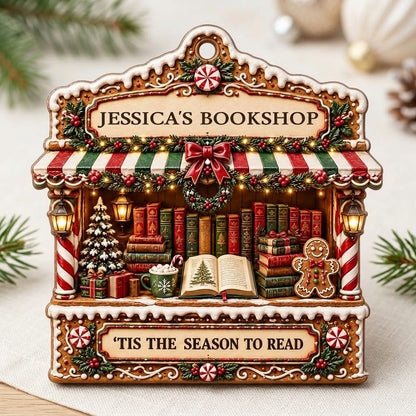 Gingerbread bookstore facade ornament with striped awning, wreath, books, lanterns, and 'TIS THE SEASON TO READ' text.