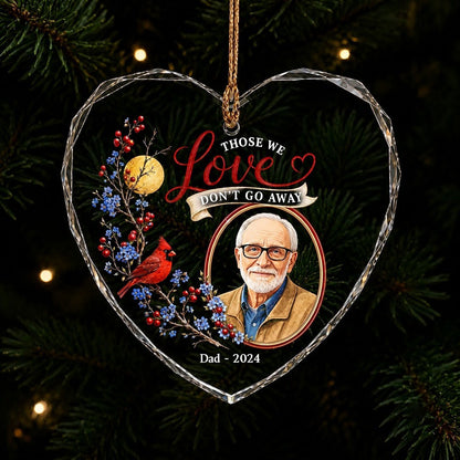 Heart-shaped glass ornament with a red cardinal, golden moon, photo frame and the quote 'THOSE WE Love DON'T GO AWAY'.