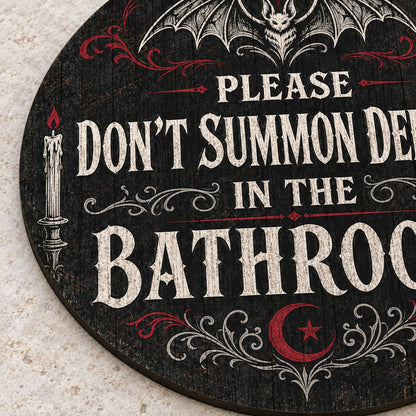 Round wooden sign with bat, filigree, candles and a crescent moon reading PLEASE DON'T SUMMON DEMONS IN THE BATHROOM.