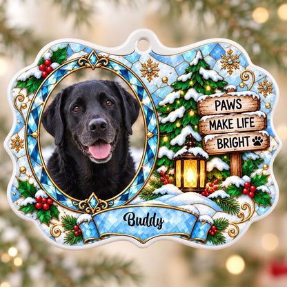 Scalloped ceramic medallion ornament with dog photo, blue stained glass frame, lantern, and Christmas tree in snow.