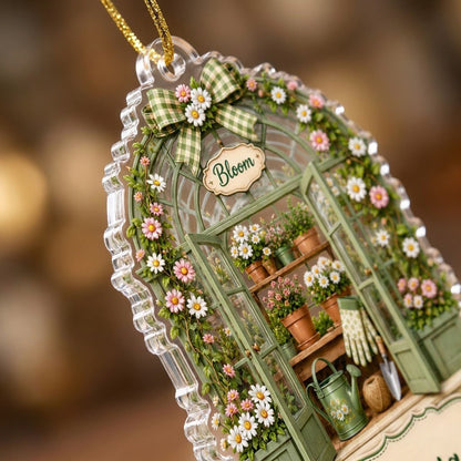 Arched acrylic ornament of a green greenhouse with daisy bow, flowers, tools, and 'Bloom' with a personalized name.