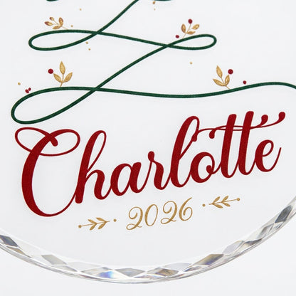 Clear round glass ornament with a looping green line Christmas tree topped by a small gold heart, name and year.