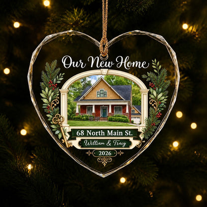 Heart glass ornament with archway, brick and yellow house, pine branches, gold key, and 'Our New Home' text.