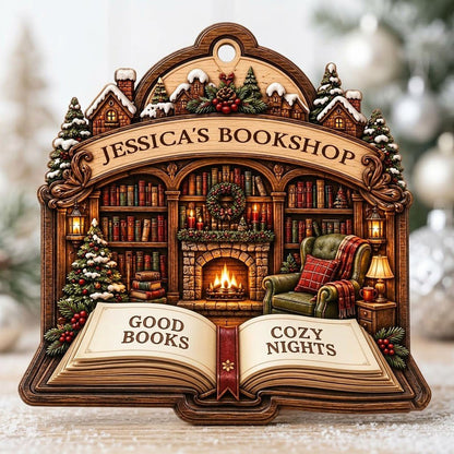 Custom-cut wood ornament with arched loop and open book base, cozy bookshop scene with tree, fireplace, armchair.