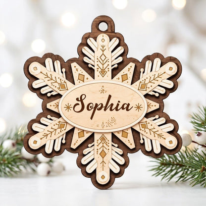 Layered wood snowflake ornament with geometric engravings and a central oval name plate for a custom name.