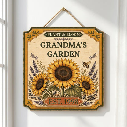 Square bracketed wooden sign with three sunflowers, lavender, a honeybee, and “Plant & Bloom” and “Grandma’s Garden” tex