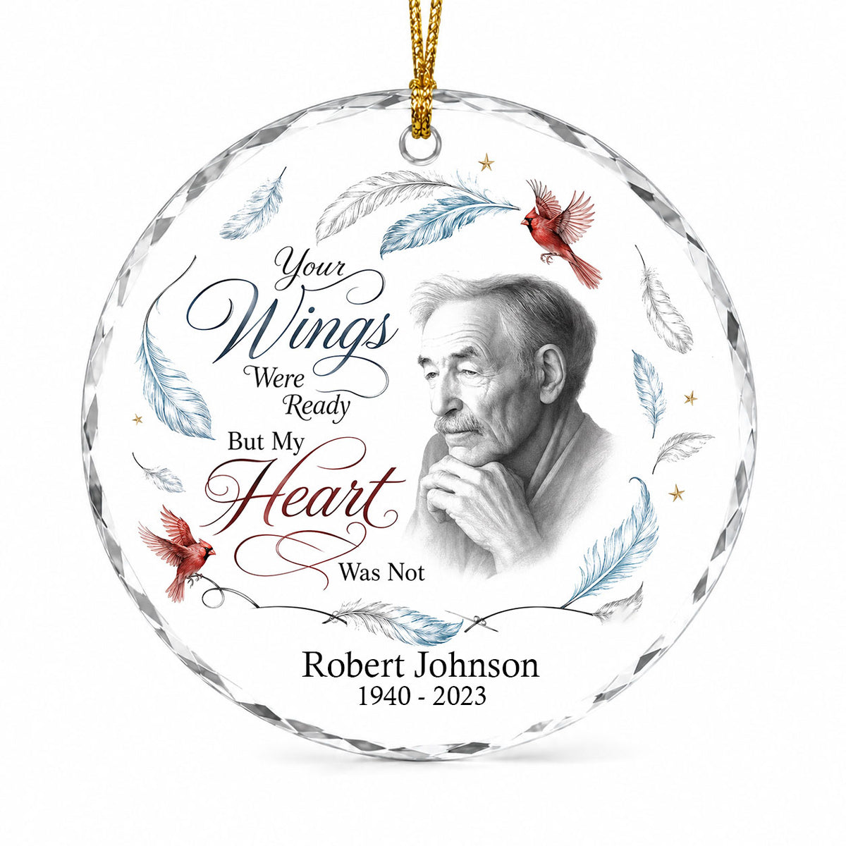 Round glass ornament with sketch portrait, two red cardinals, blue and brown feathers, and memorial name and years.