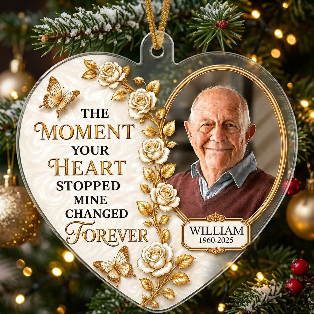 Heart-shaped acrylic ornament with a photo in a gold oval frame, white roses, gold butterflies, and a name plaque.