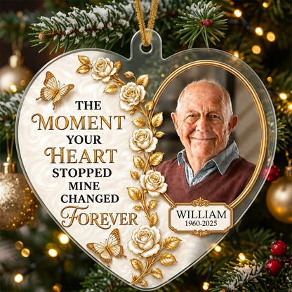 Heart-shaped acrylic ornament with a photo in a gold oval frame, white roses, gold butterflies, and a name plaque.