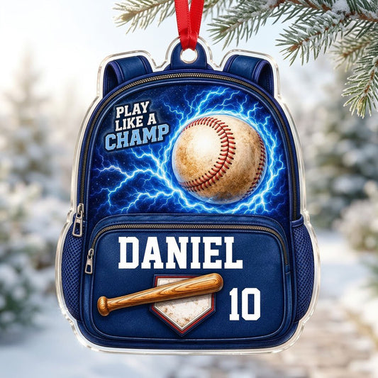 Backpack-shaped acrylic ornament with a baseball, blue lightning, a bat on home plate, and PLAY LIKE A CHAMP text.