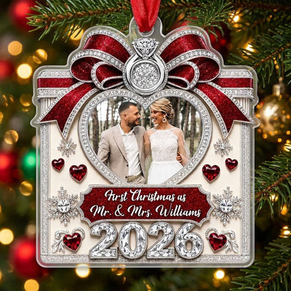 Acrylic ornament with red glitter bow, engagement ring, heart photo frame, snowflakes, and Mr. & Mrs. name and year.