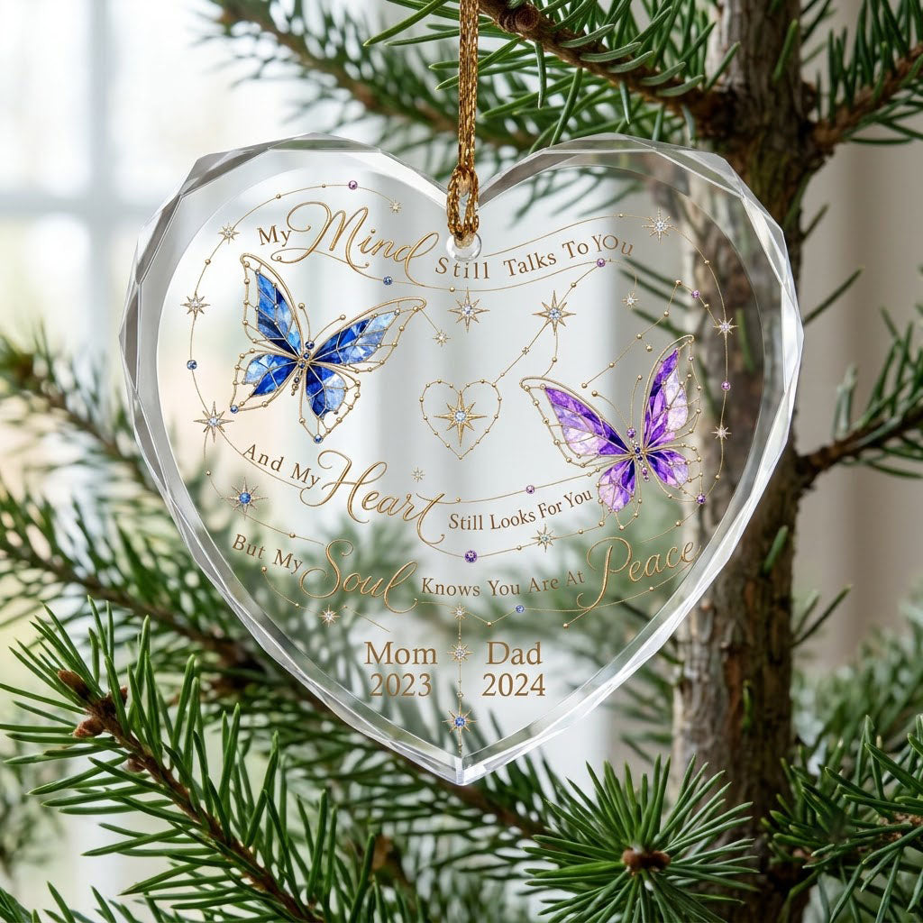 Heart-shaped glass ornament with blue and purple stained-glass butterflies, gold swirls, and memorial text.