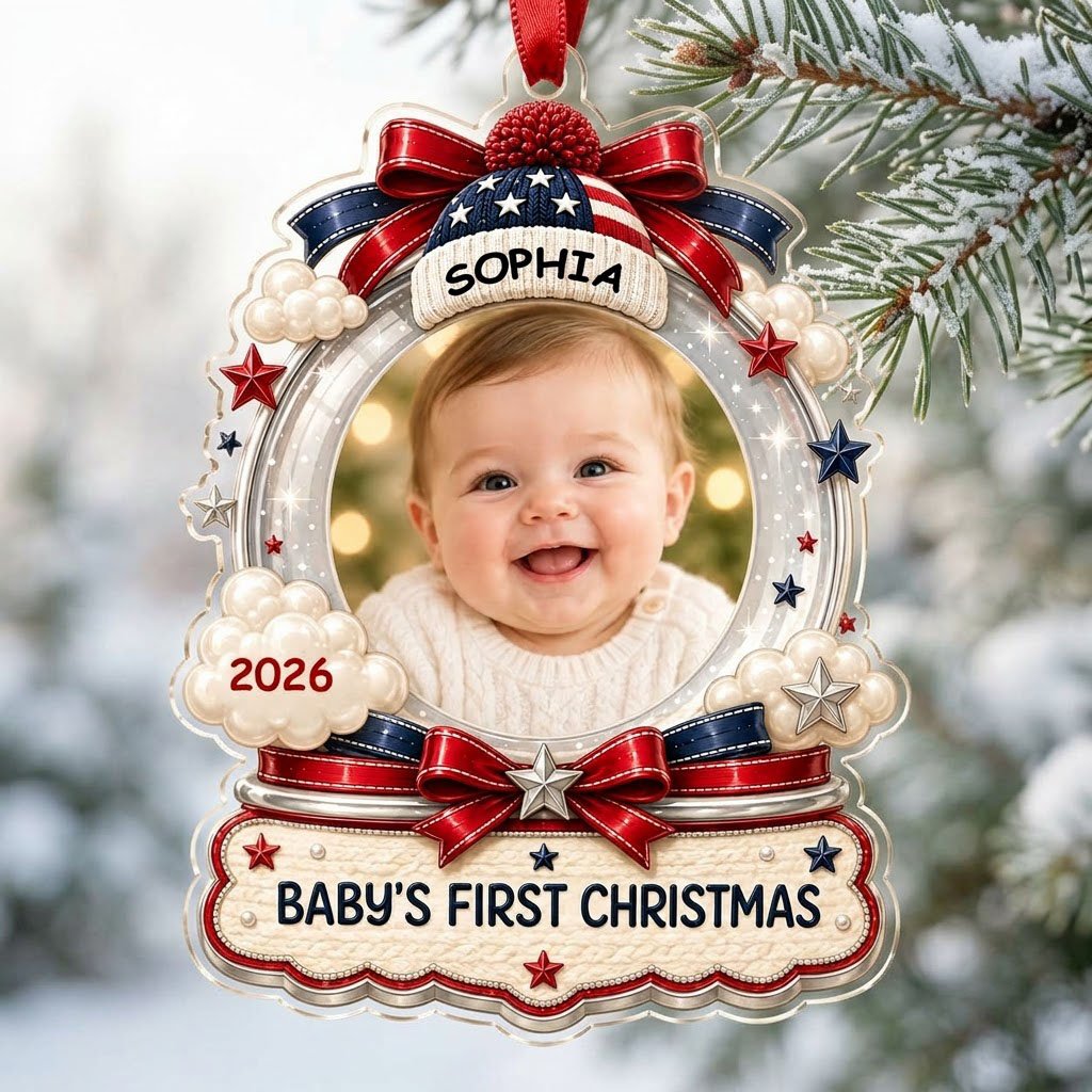 Custom-cut acrylic ornament with baby's photo, patriotic beanie, red bows, stars, and 'Baby's First Christmas' banner.