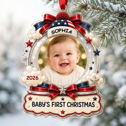 Custom-cut acrylic ornament with baby's photo, patriotic beanie, red bows, stars, and 'Baby's First Christmas' banner.