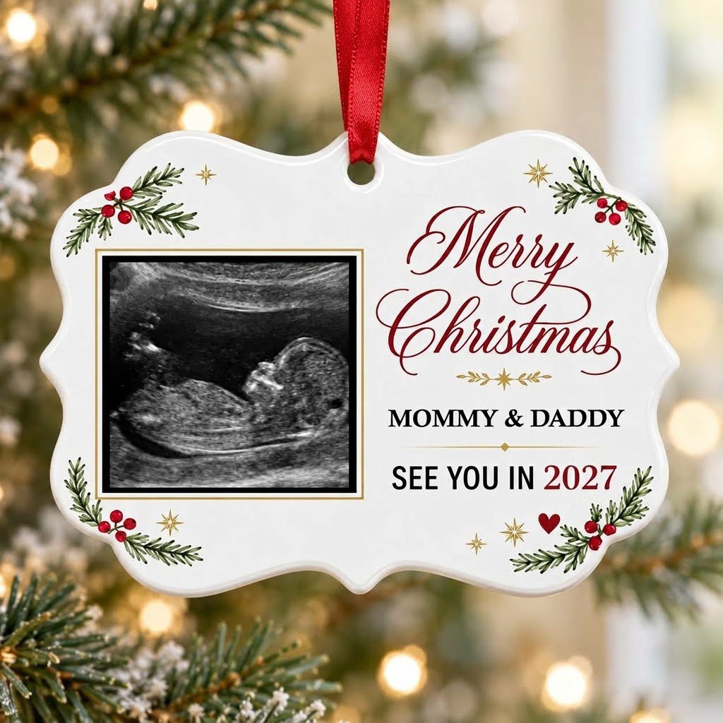 Round ceramic ornament with ultrasound photo, pine branches with red berries, gold starbursts and a red heart icon.