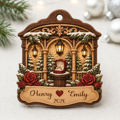 Arched wood ornament with three lanterns, pine trees, red roses, and an open ring box on a central pedestal.