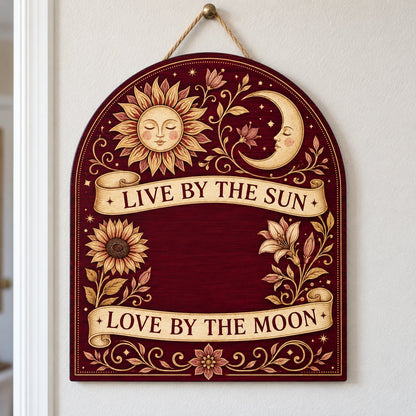 Arch sign with sleeping sun and moon, sunflower and lilies, banners reading Live by the Sun and Love by the Moon.
