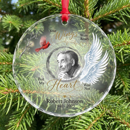 Round glass ornament with a sketch portrait frame, blue angel wing, red cardinal and 'Your Wings Were Ready' memorial te