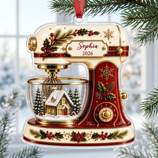 Stand mixer-shaped acrylic ornament with holly, gold snowflakes, and a snowy cottage scene in a glass bowl.