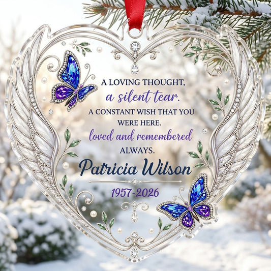 Heart-shaped clear acrylic ornament with silver angel wings, blue and purple butterflies, pearls, and memorial text.