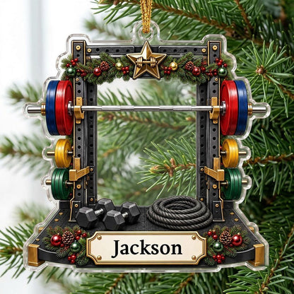 A squat rack-shaped acrylic ornament with garland, barbell, dumbbells, and a photo cutout above a name plaque.