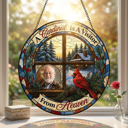 Stained glass suncatcher with a wooden four-pane window, snowy cabin scene, red cardinal on pine branches, and a circula